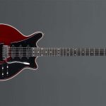 Guitarra Red Special, feita à mão por Brian May e seu pai, com acabamento vermelho escuro, três captadores single-coil e corpo com entalhes suaves, encostada sobre um estojo preto.