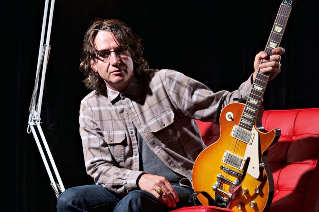 Stone Gossard do Pearl Jam sentado com sua guitarra Gibson Les Paul sunburst.
